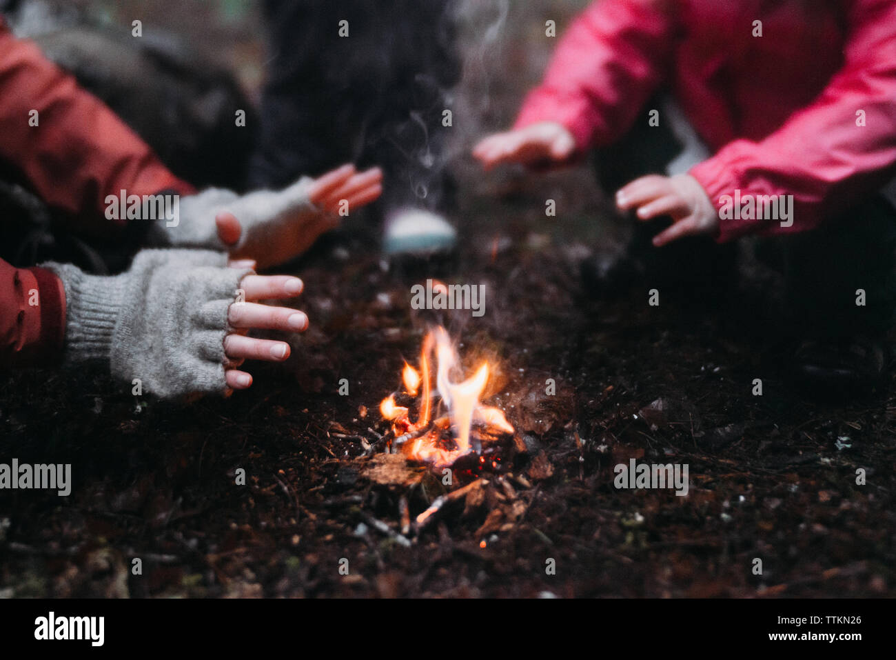 Bild von Mutter und Tochter Erwärmung der Hände am Lagerfeuer 7/8 Stockfoto