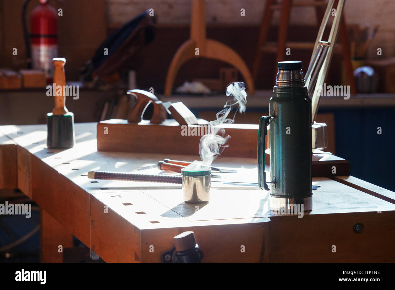 Isolierte drink Container mit Werkzeugen auf Tisch in der Werkstatt Stockfoto