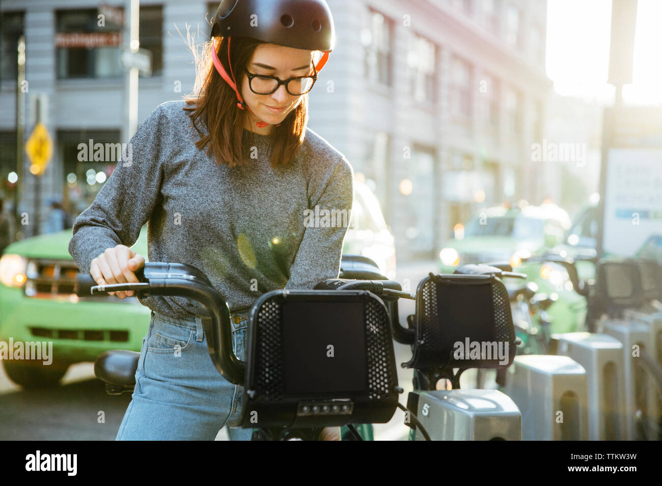Junge Frau Entriegelung bike Teilen auf der Straße Stockfoto