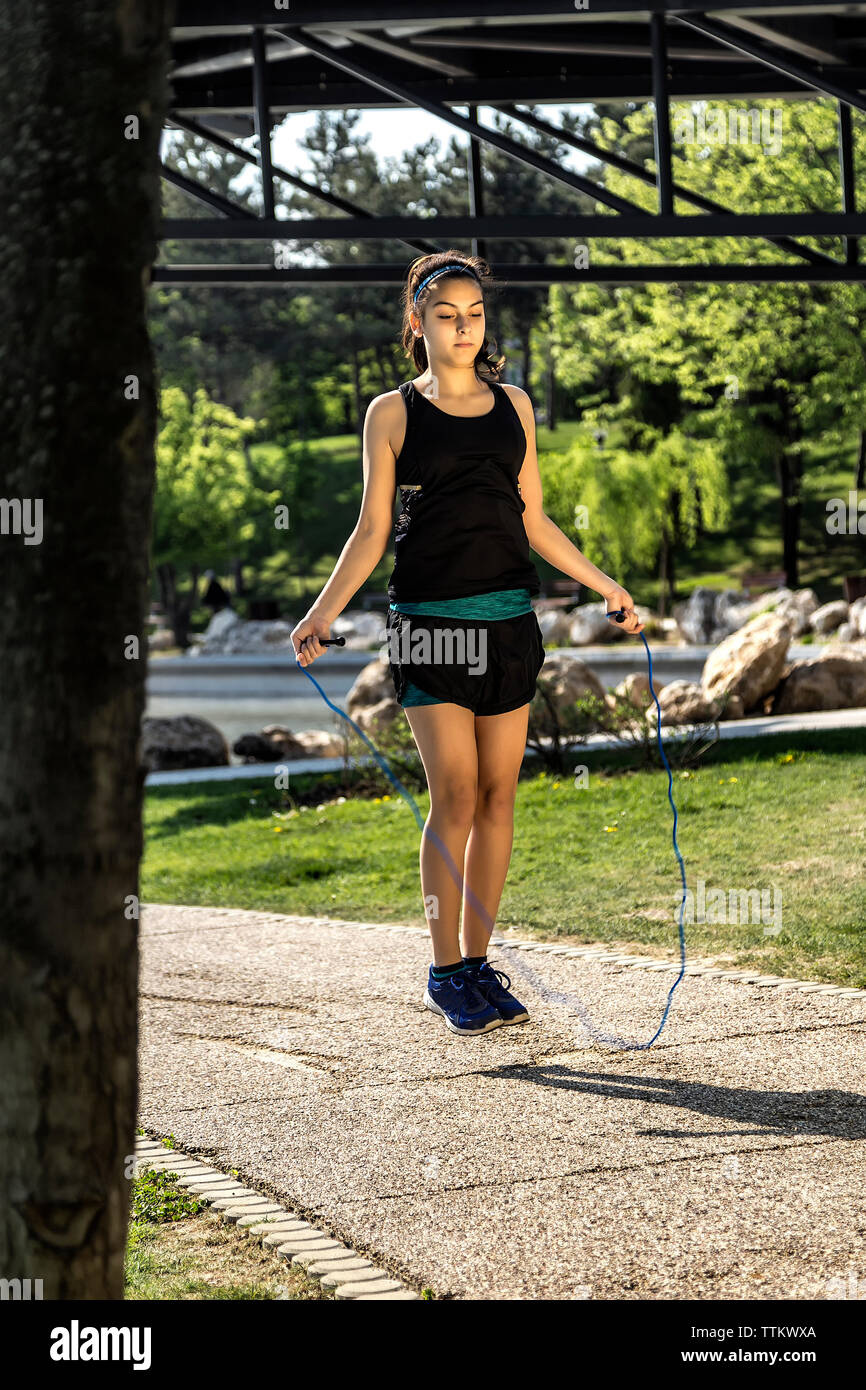 Weibliche Athleten überspringen mit Seil springen auf Fußweg im Park Stockfoto