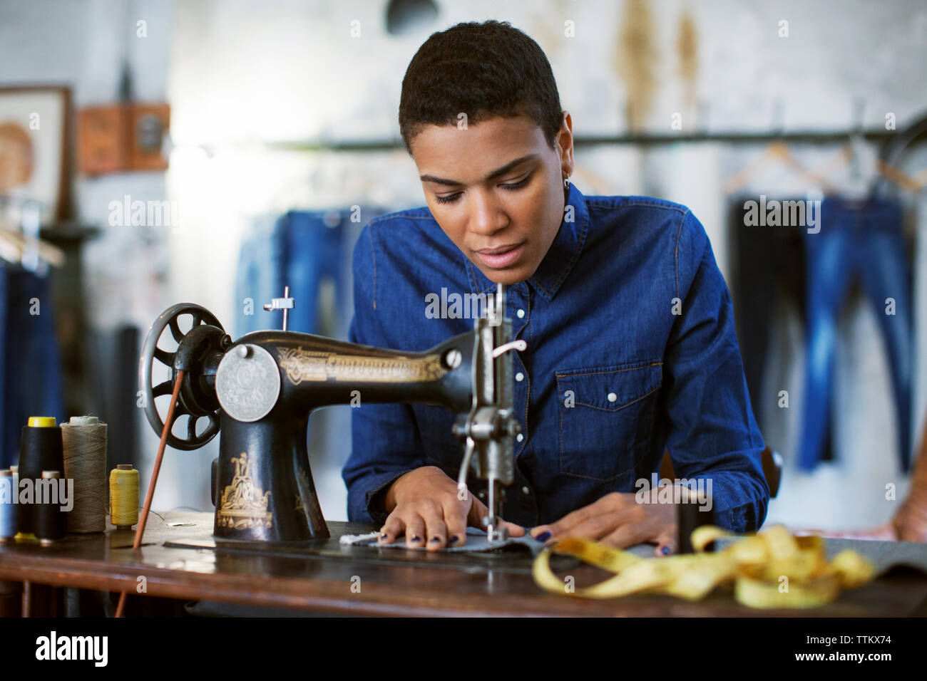 Weibliche Mode Designer mit Nähmaschine in Werkstatt Stockfoto
