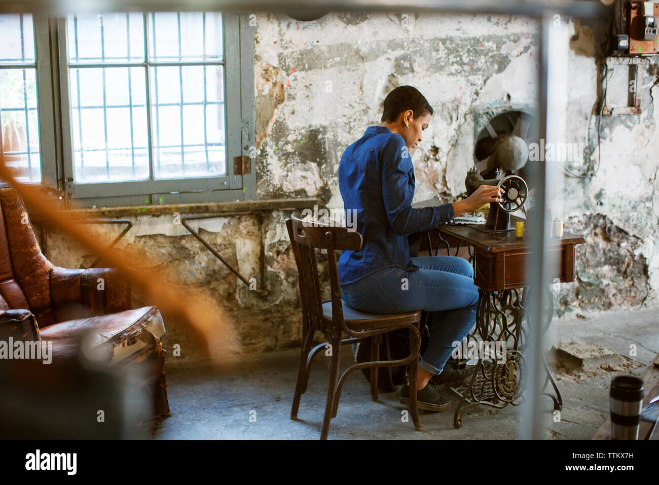 Weibliche Mode Designer arbeiten auf der Nähmaschine in der alten Werkstatt Stockfoto
