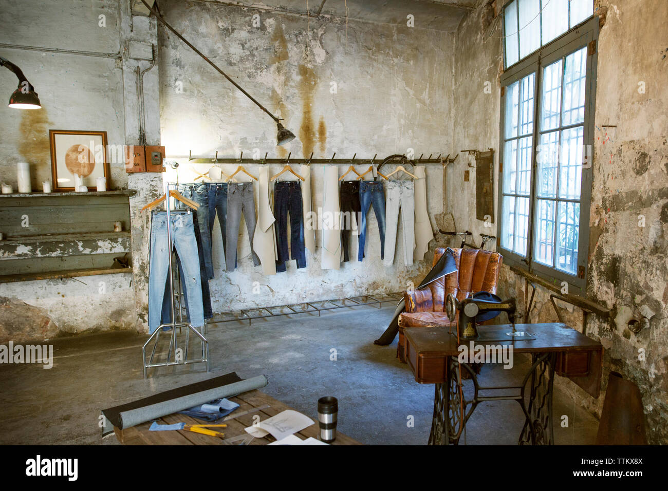 Jeans hängen an Rack in der alten Werkstatt Stockfoto