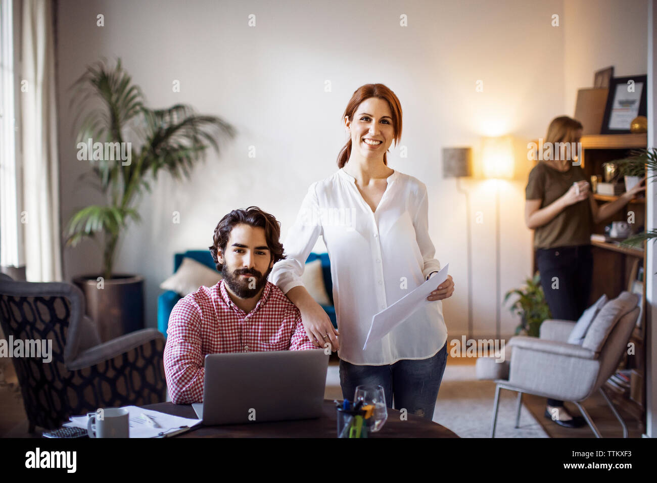 Portrait von Happy Geschäftsfrau mit männlichen Kollegen am Tisch in der kreativen Büro Stockfoto