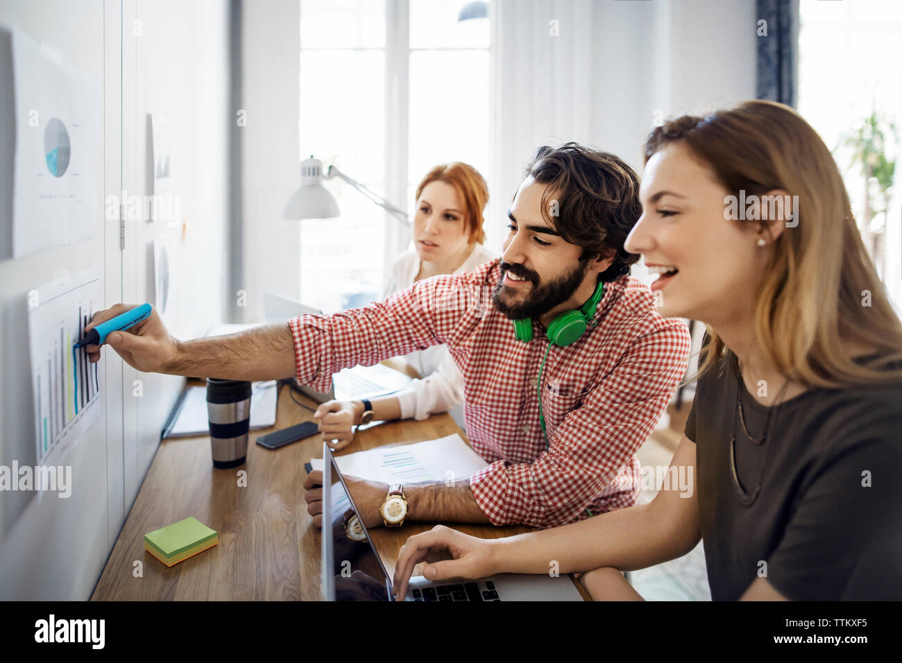 Happy Geschäftsmann Kennzeichnung auf dem Papier während der Sitzung mit den Kollegen im Büro Stockfoto