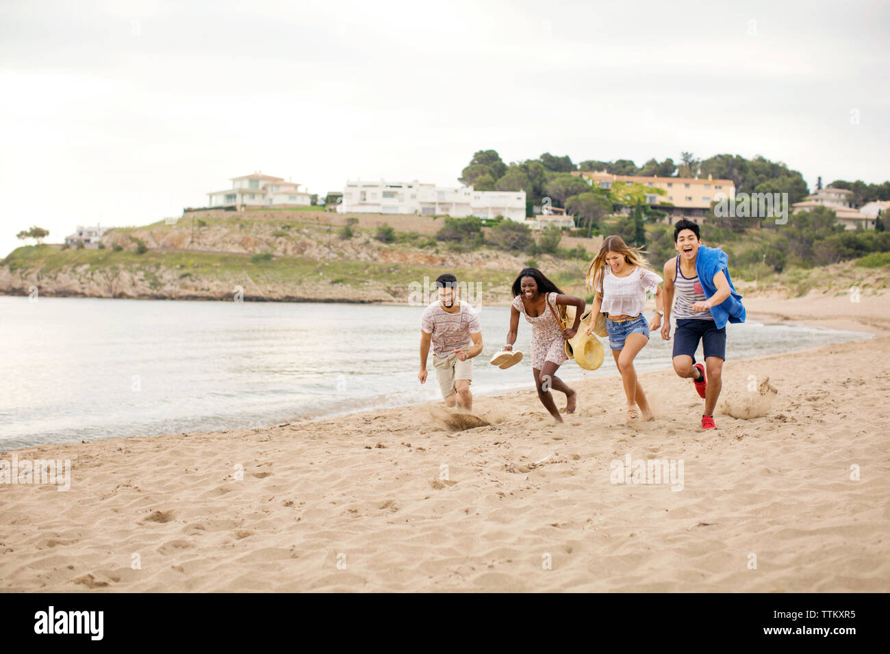 Verspielter Freunde auf Ufer am Strand während der Ferien Stockfoto