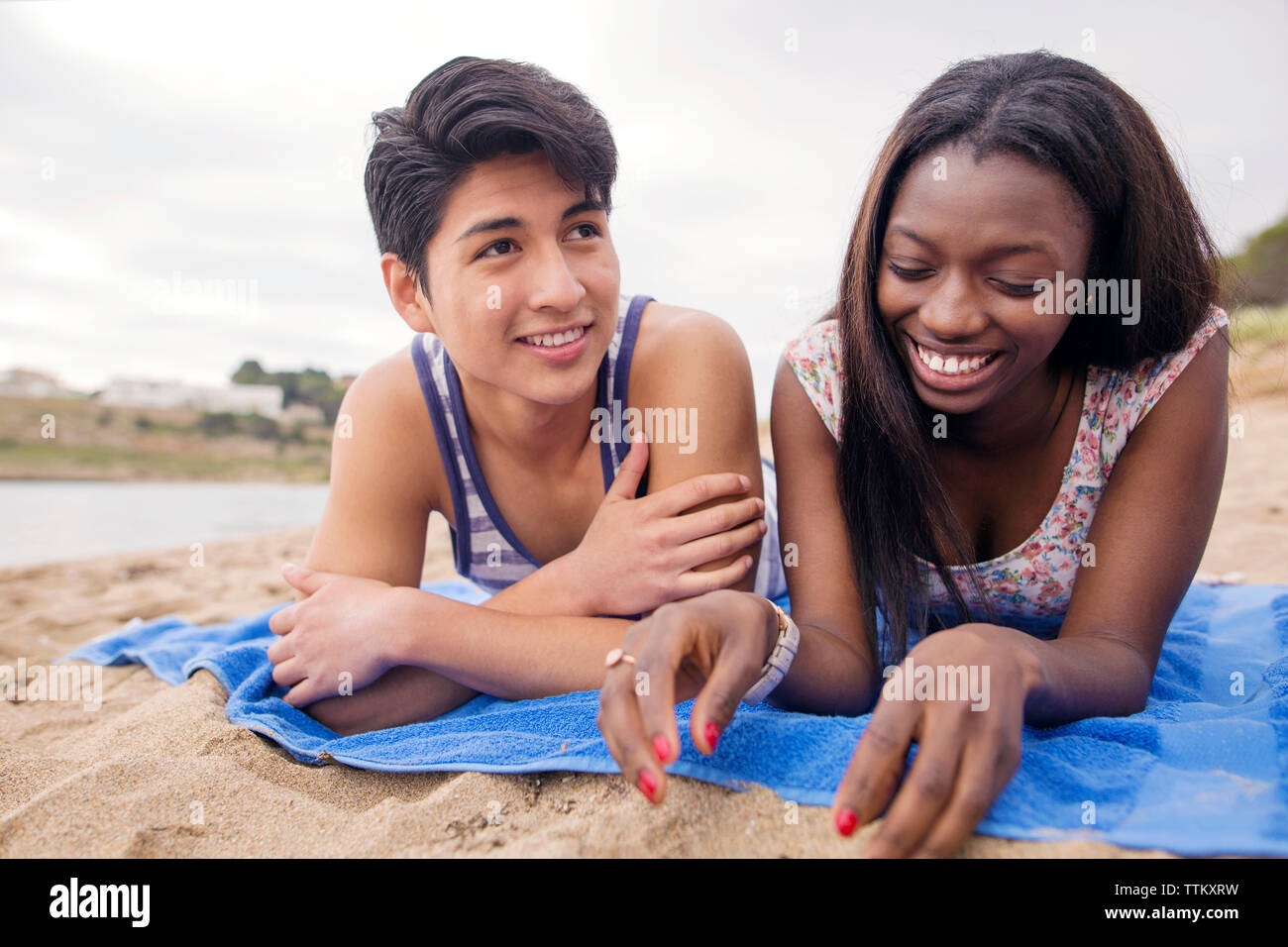 Glücklich, multi-ethnischen Paar liegen auf Decke am Strand Stockfoto
