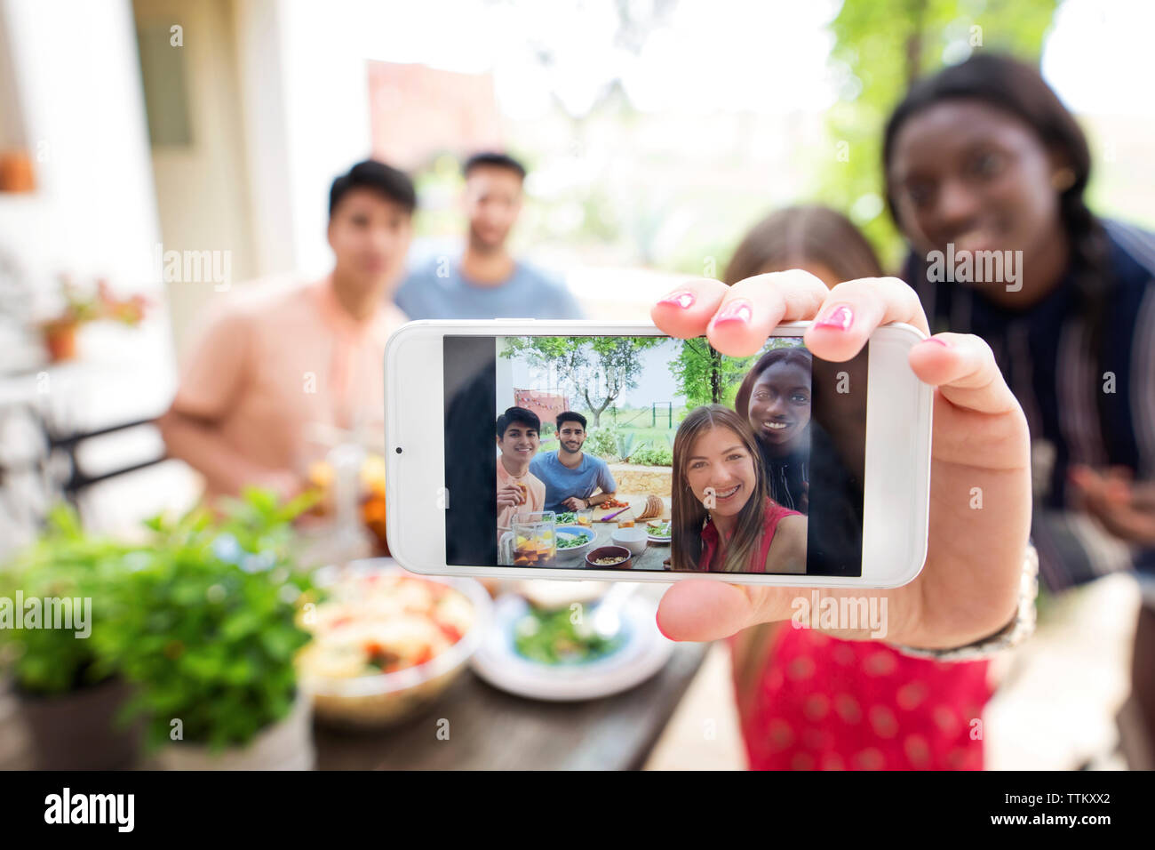 Multi-ethnischen Freunde unter selfie an zum Mittagessen im Freien Tisch Stockfoto