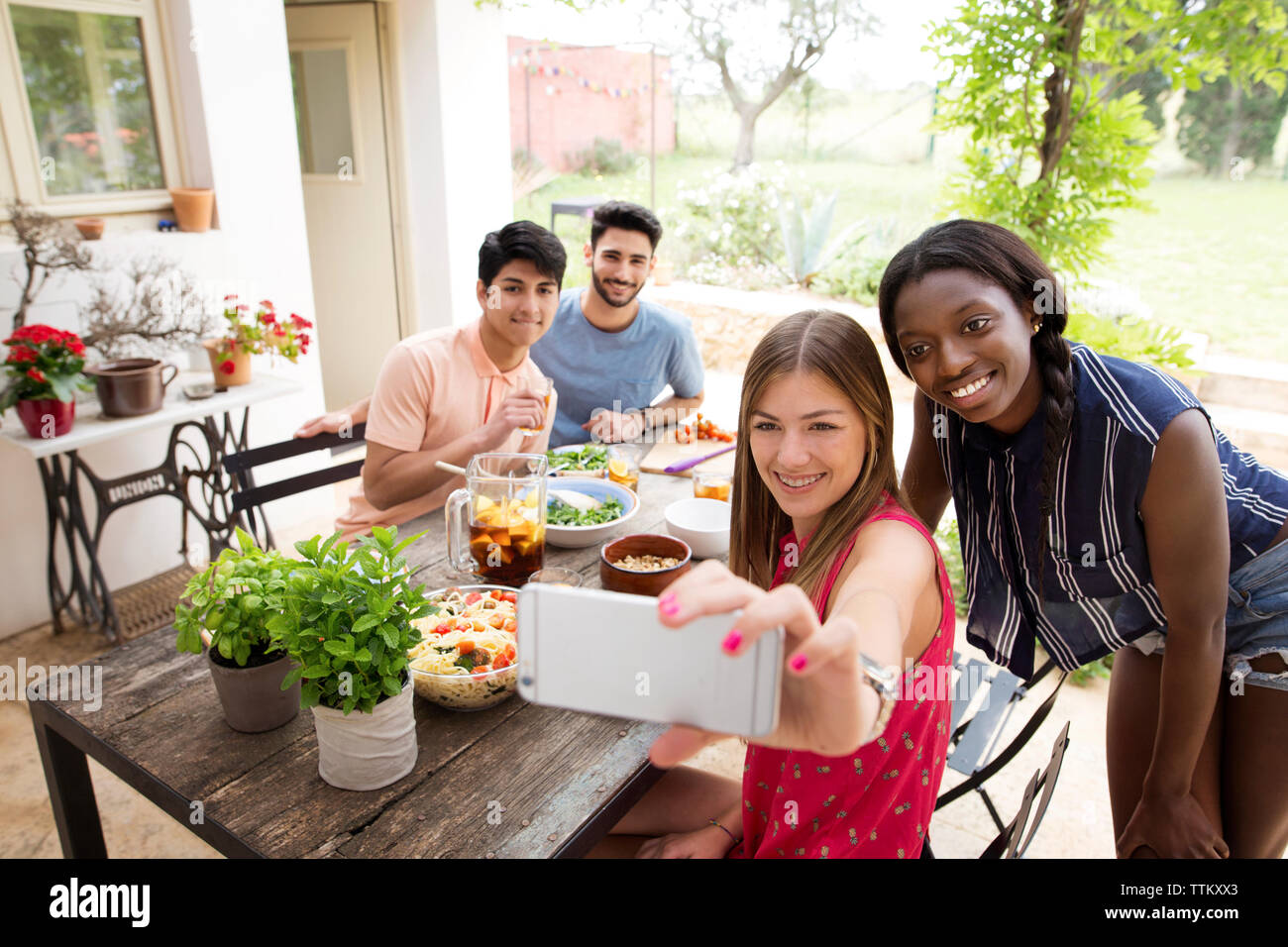 Gerne Freunde unter selfie während dem Mittagessen am Tisch im Freien Stockfoto