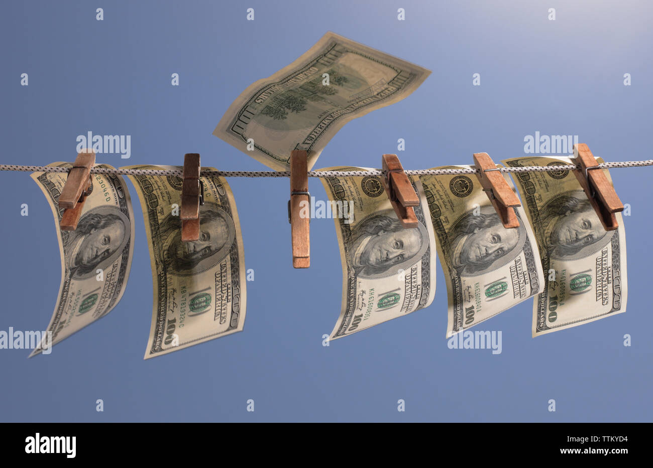 Geld hängen an einer Wäscheleine mit alten hölzernen Wäscheklammern. Das Symbol der Offshore Anlagen, Wirtschaftskriminalität und Geldwäsche. Stockfoto