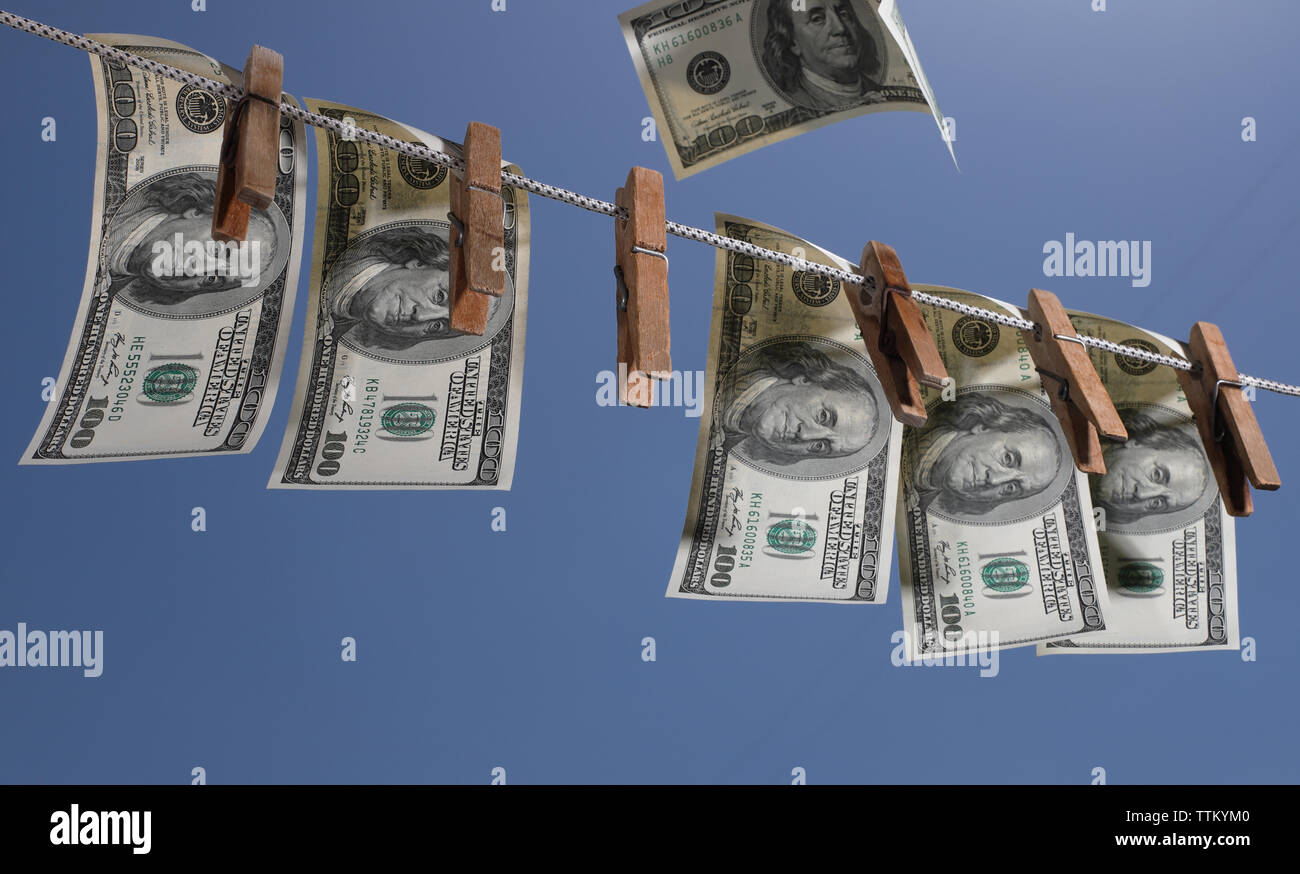 Geld hängen an einer Wäscheleine mit alten hölzernen Wäscheklammern. Das Symbol der Offshore Anlagen, Wirtschaftskriminalität und Geldwäsche. Stockfoto