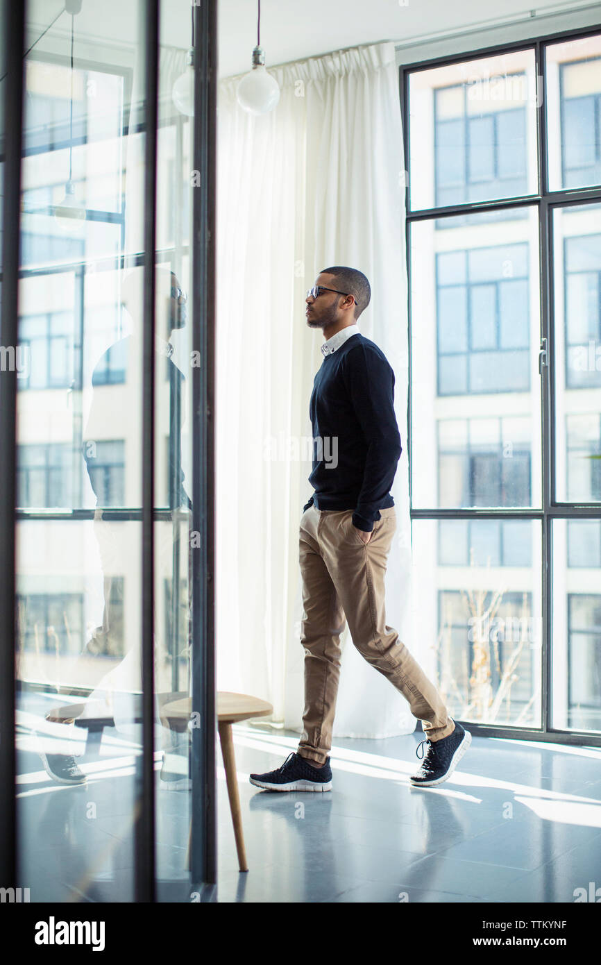 Seitenansicht der Geschäftsmann mit Händen in den Taschen wandern im Büro Flur Stockfoto