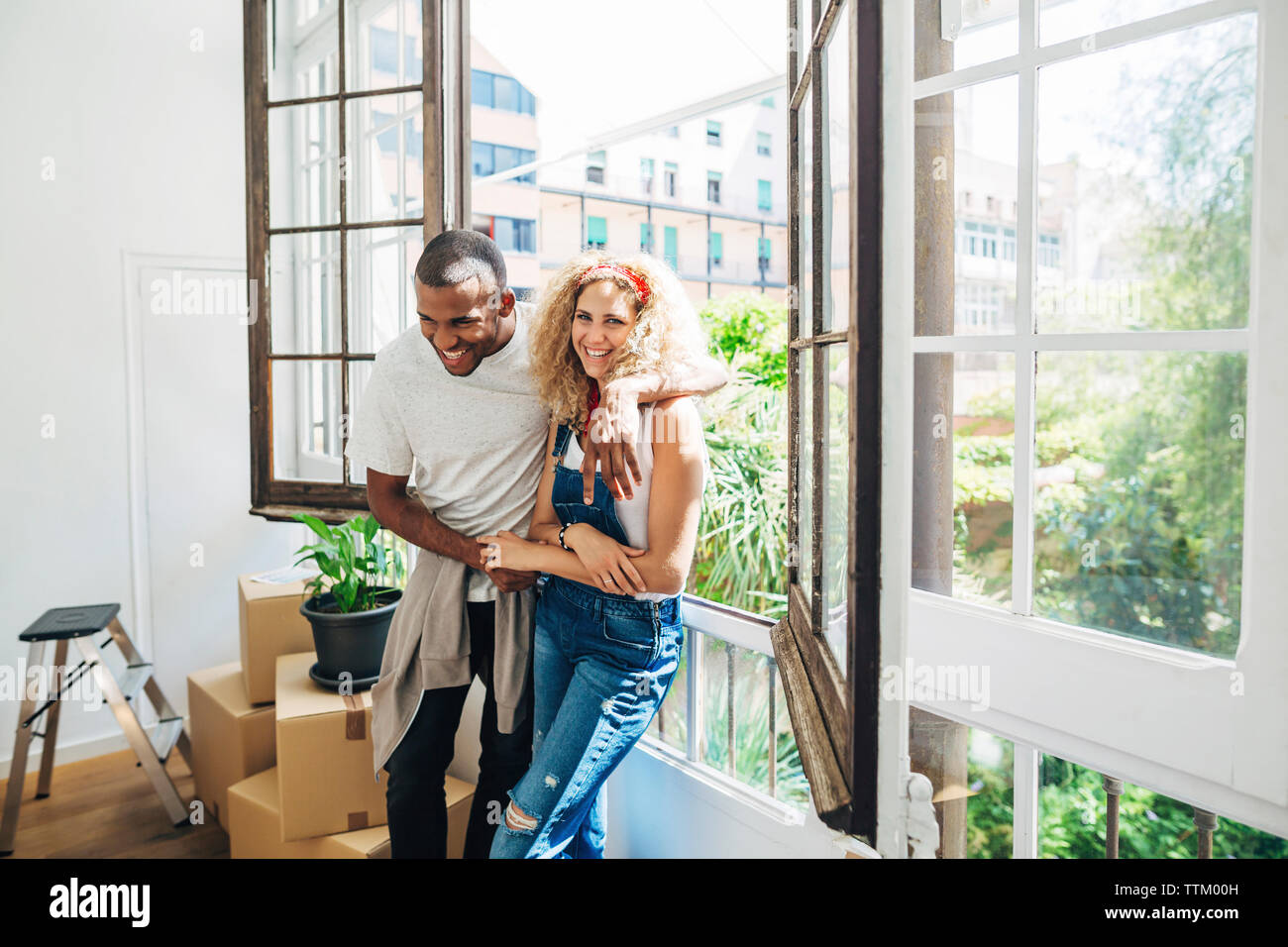 Portrait von Fröhliche Frau mit Mann durch das Fenster in neues Haus Stockfoto