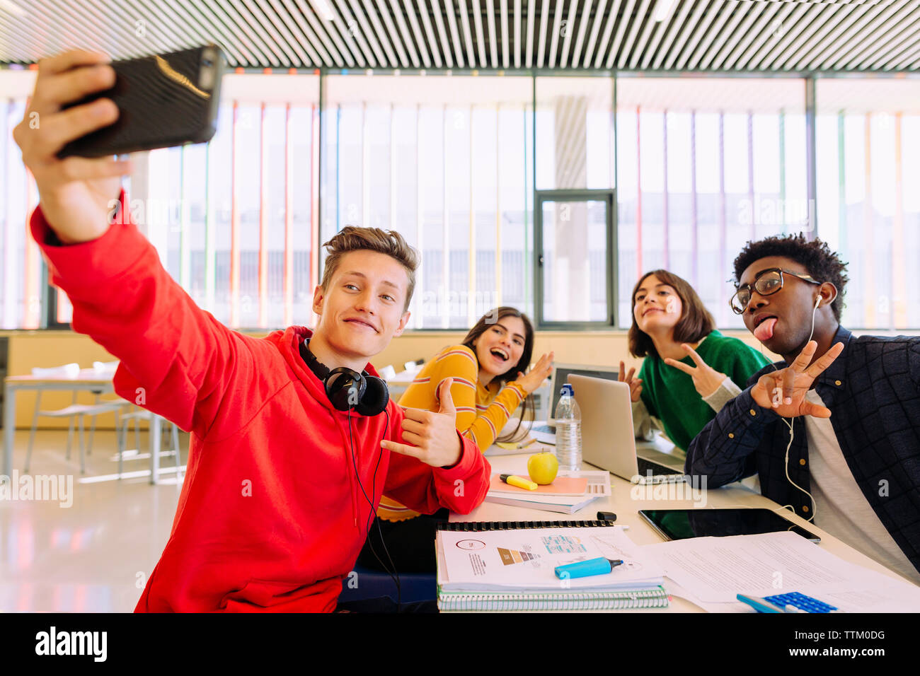 Mann unter selfie mit Freunden am Tisch in der Bibliothek Stockfoto