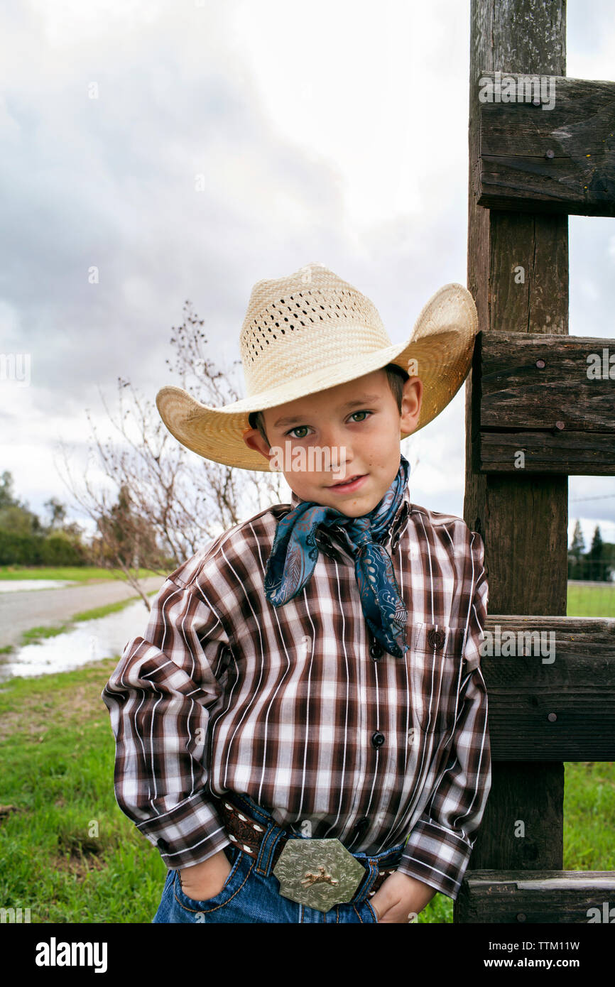 Portrait von cute Cowboy mit Händen in den Taschen auf dem Feld Stockfoto
