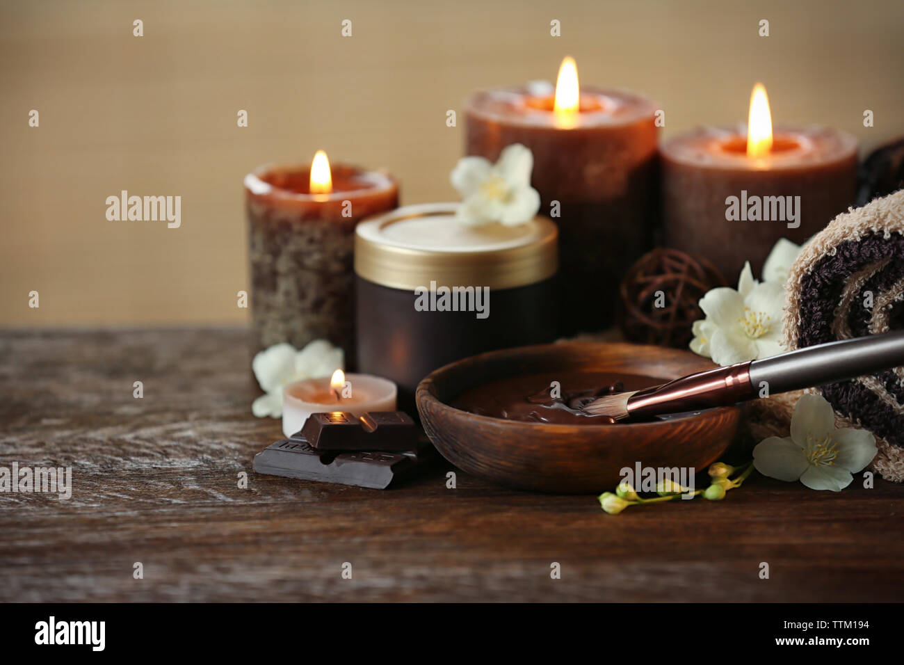 Spa Schokolade mit Kerzen auf braunem Hintergrund Stockfoto