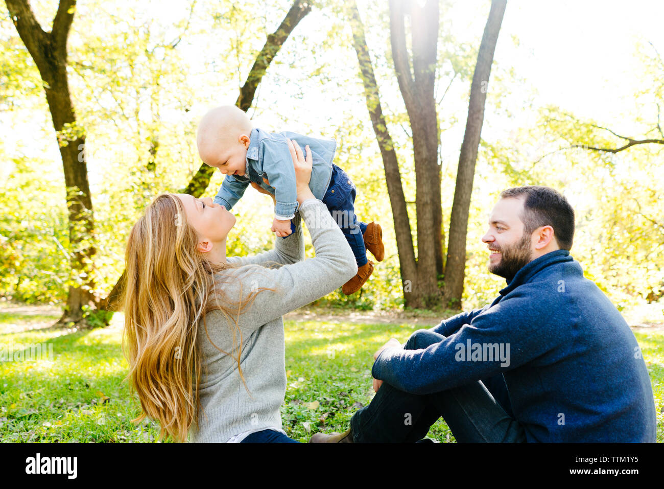 Eine Mutter hebt Ihr Baby in die Luft, während Vati auf sieht Stockfoto
