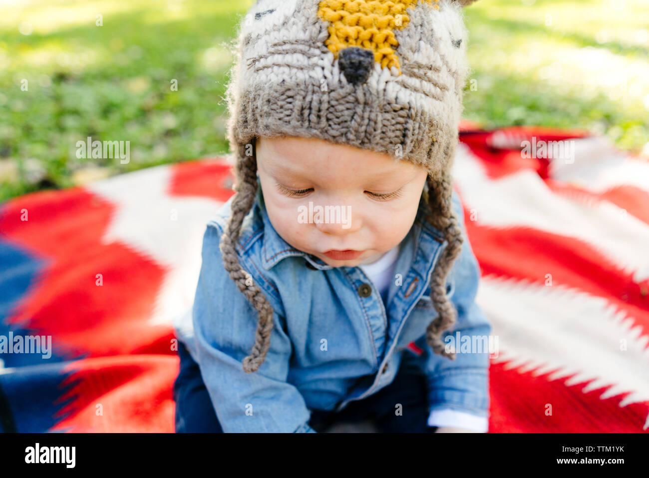 Ein baby boy trägt einen Strumpf Hut sitzt auf einer Decke Stockfoto