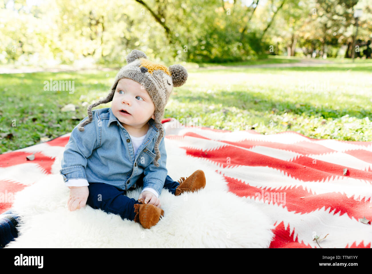 Ein baby boy schaut weg, während auf einer Decke Sitzen Stockfotografie -  Alamy