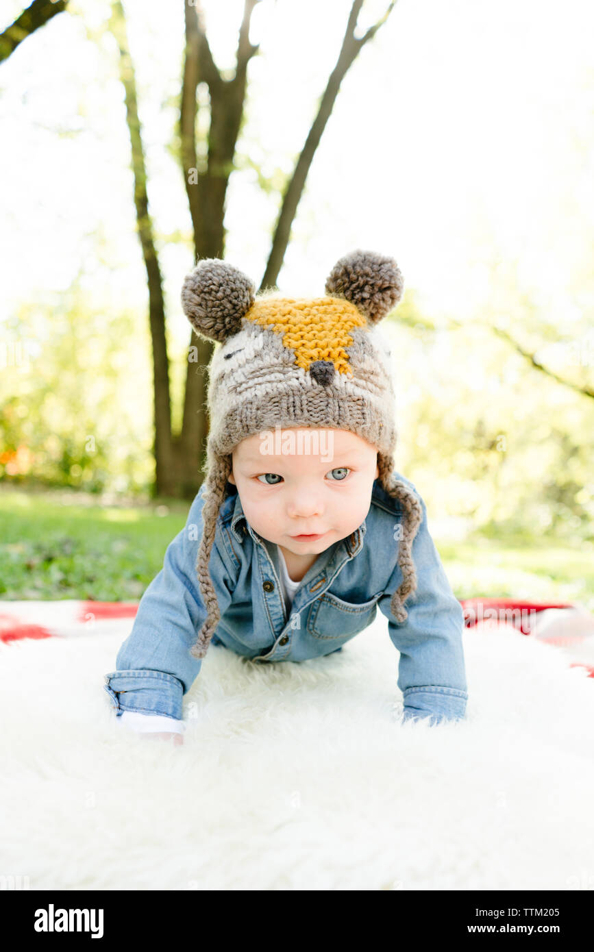 Einen Jungen in einen Hut kriecht über einer Decke Stockfoto