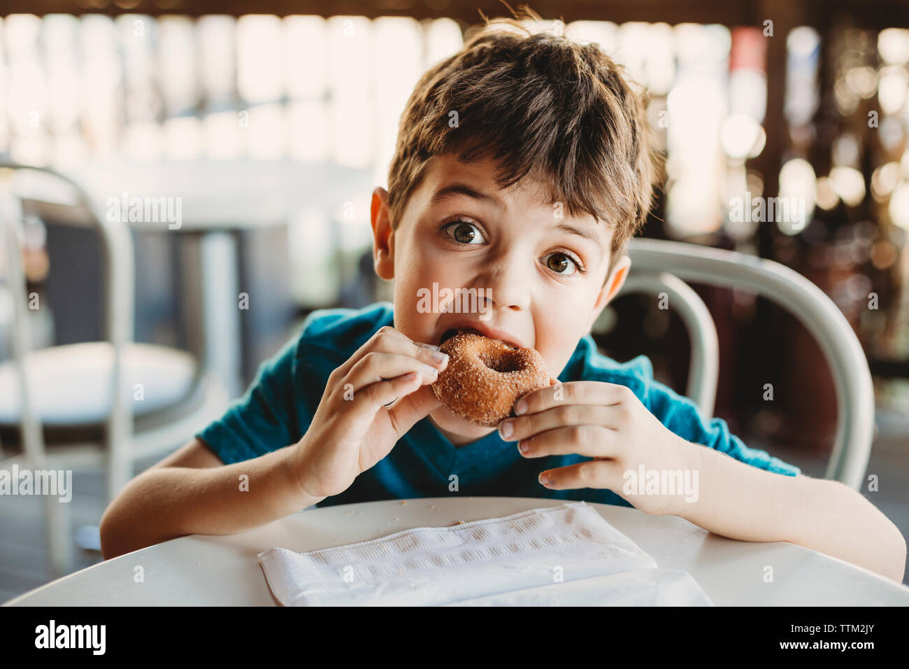 Porträt der jungen Donut Essen im Restaurant Stockfoto