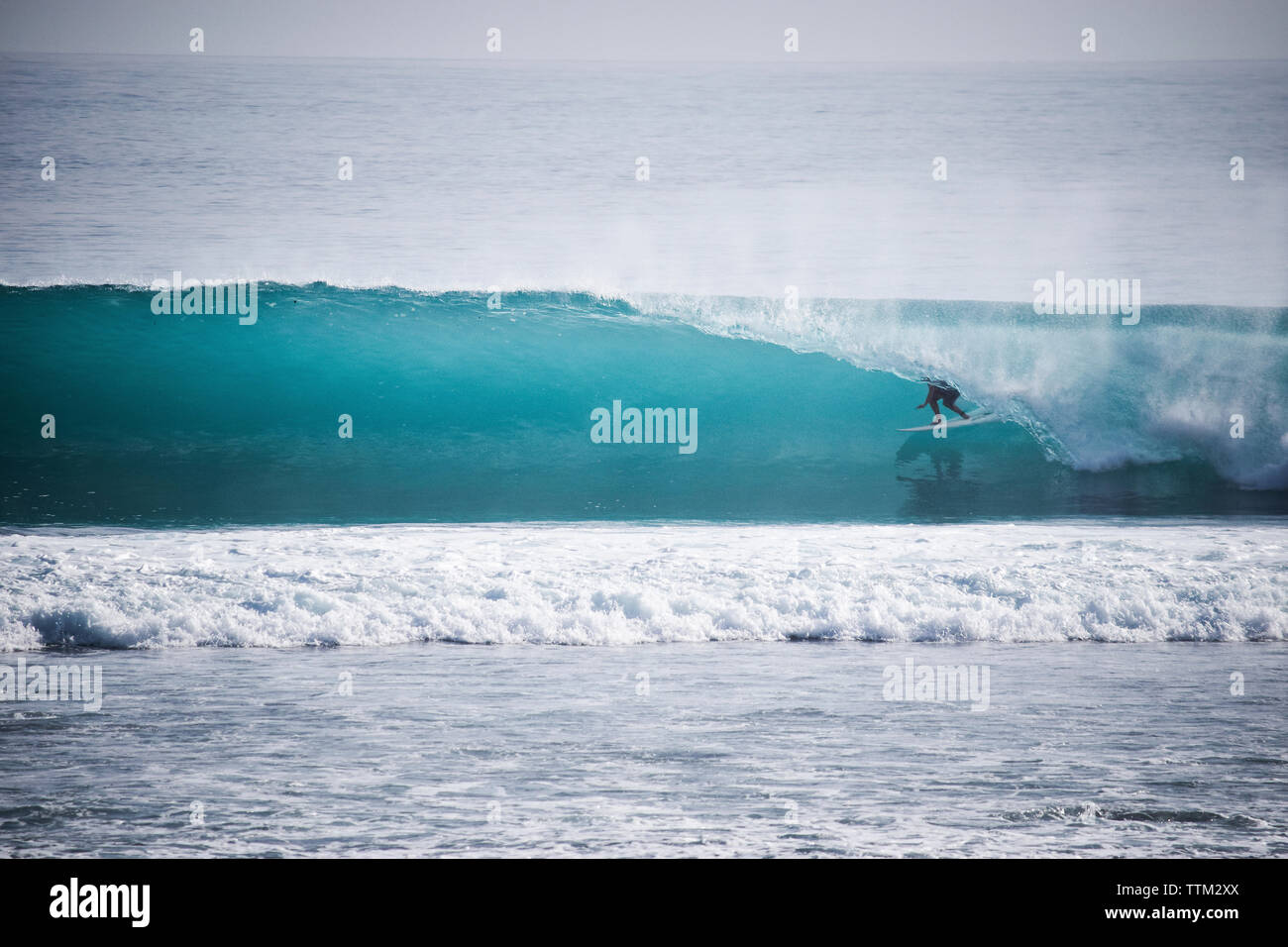Person surfen in Rolling Surf bei Mentawai Inseln Stockfoto