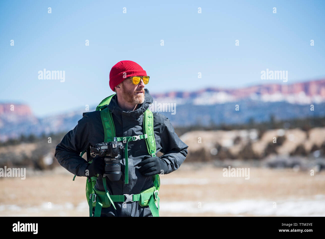 Wanderer mit Rucksack und Kamera stehen an der Wüste im Winter Stockfoto