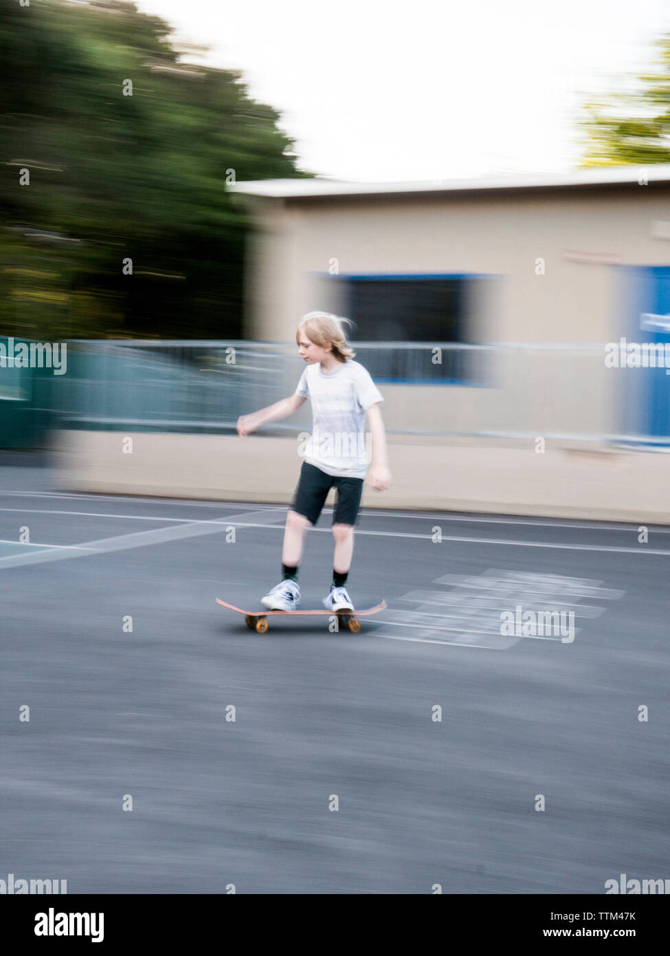 Verschwommene Bewegung von jungen Skateboarding auf der Straße Stockfoto