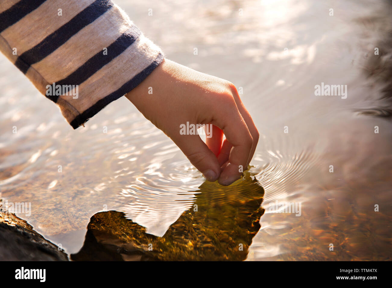 Zugeschnittenes Bild von Hand Wasser berühren. Stockfoto