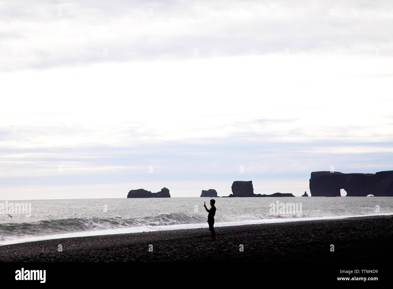 Tourist, Handy Foto am Strand Reynisfjara Island Stockfoto