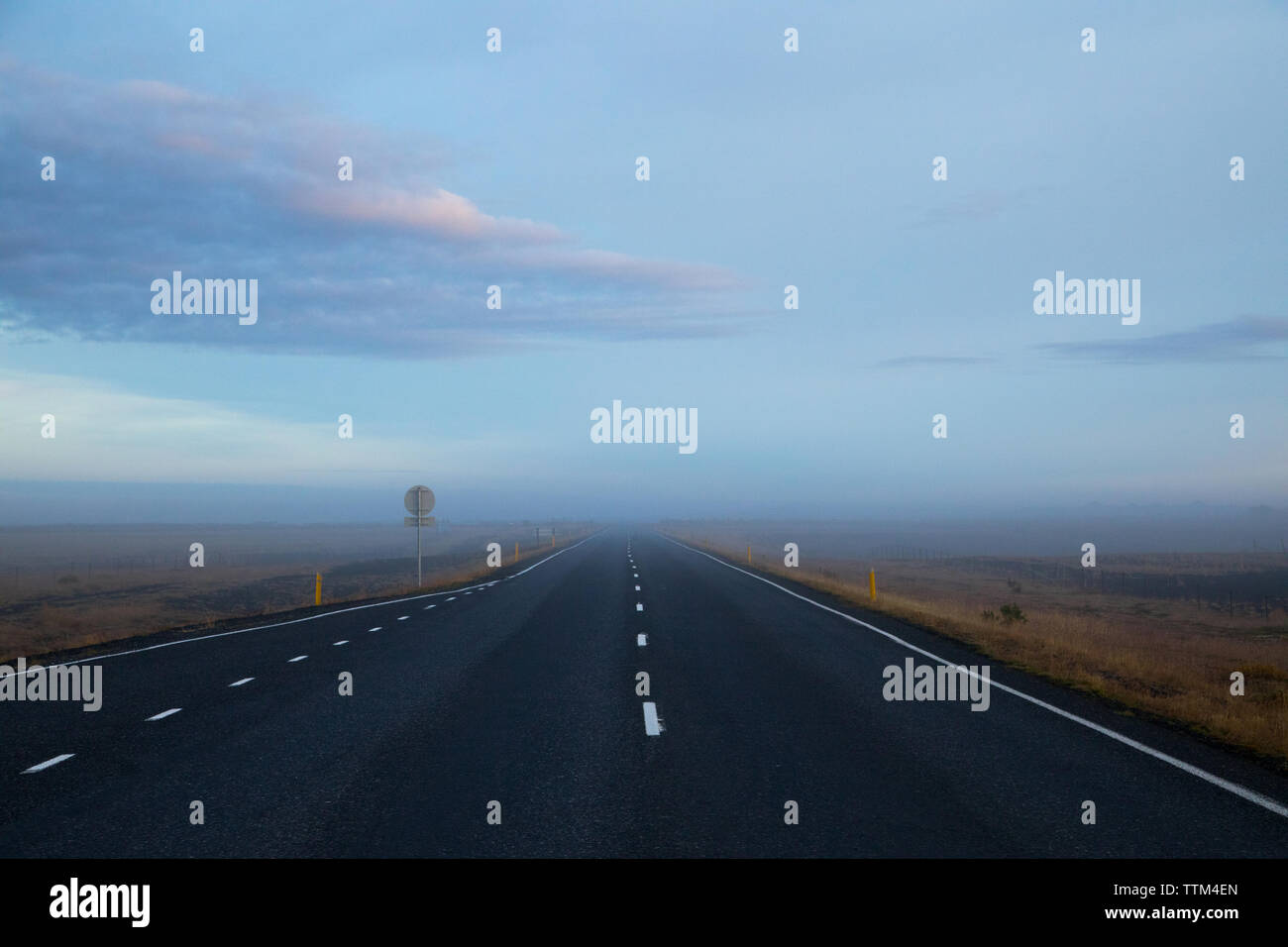 Misty Blick auf leere Straße in der Morgendämmerung in Island Stockfoto