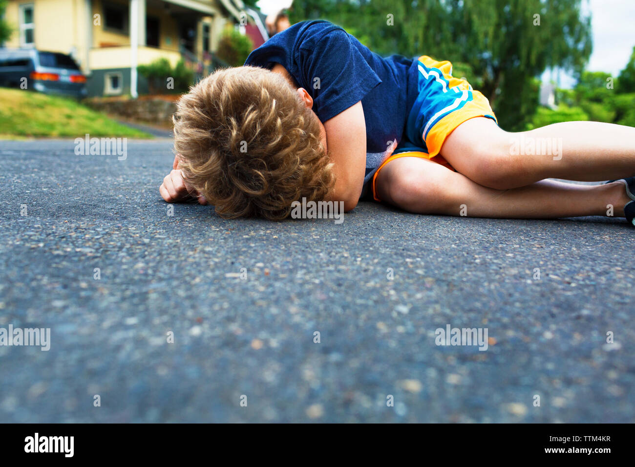 Traurige junge liegend auf der Straße Stockfoto