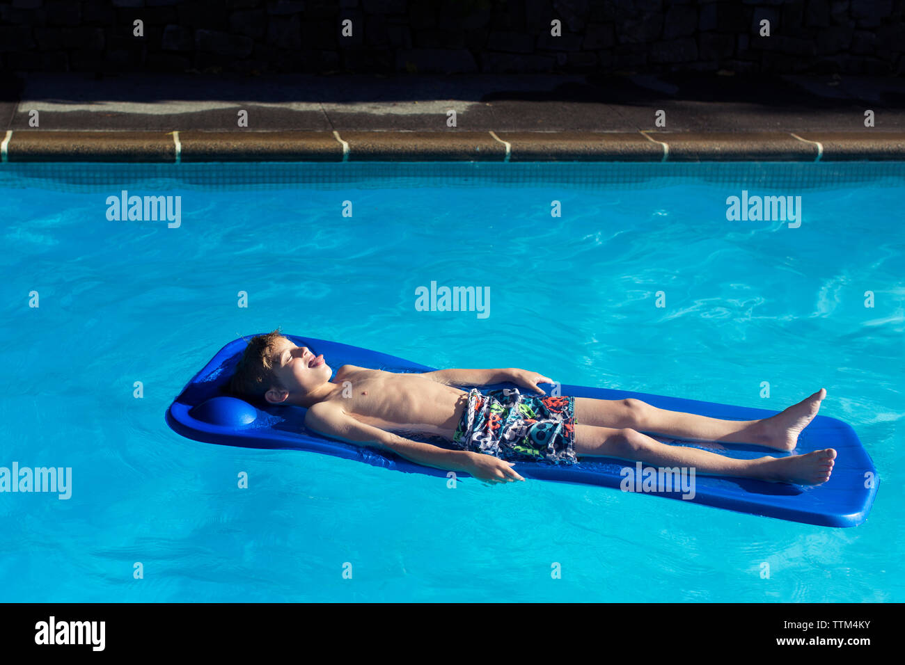 Hohe Betrachtungswinkel der Boy entspannen auf aufblasbaren Floß im Pool Stockfoto