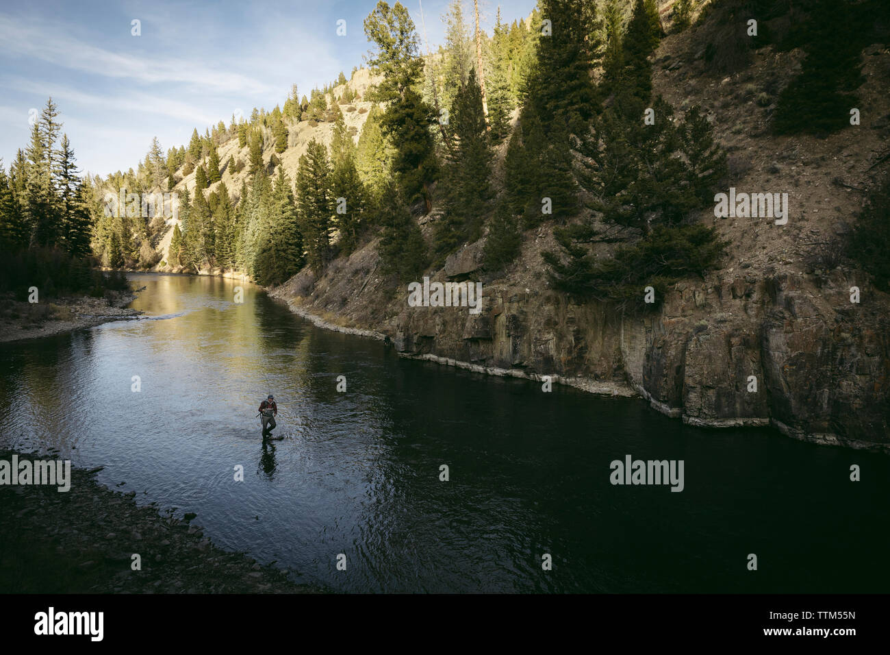 Hohe Betrachtungswinkel von Mann angeln im Fluss inmitten der Berge zu Wald Stockfoto
