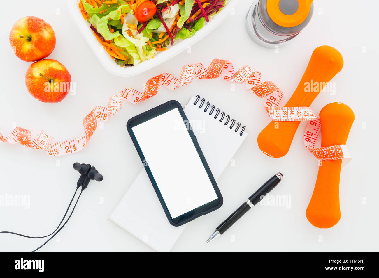 Fitness gesund und Diät Plan mockup auf Tablet mit leerer Bildschirm Mobiltelefon Mockup, Ohrhörer, Flasche Wasser, Salat, Äpfel und Messung der Ta Stockfoto