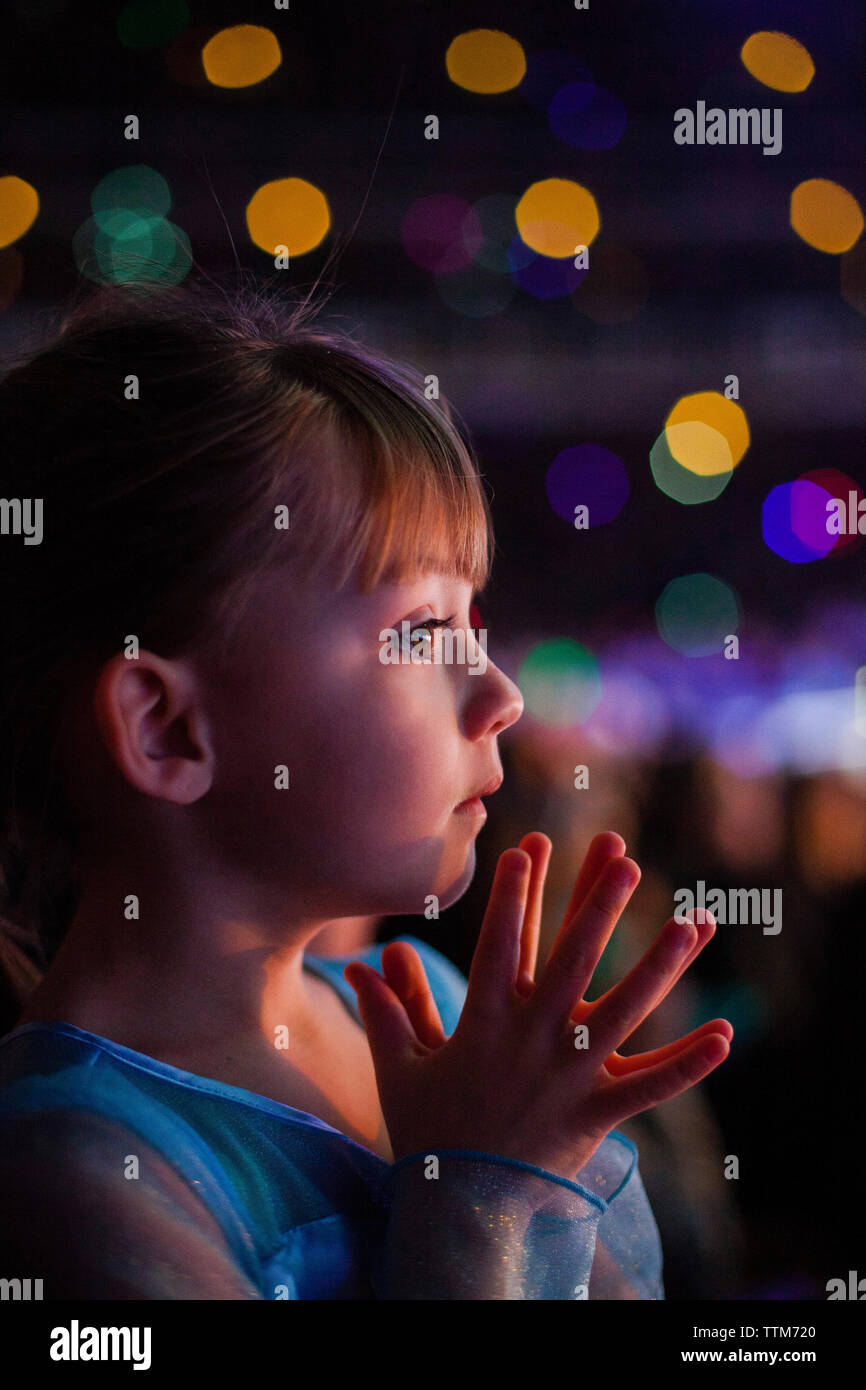 Close-up von nachdenklich Mädchen gegen defokussierten Lichter in der Nacht Stockfoto