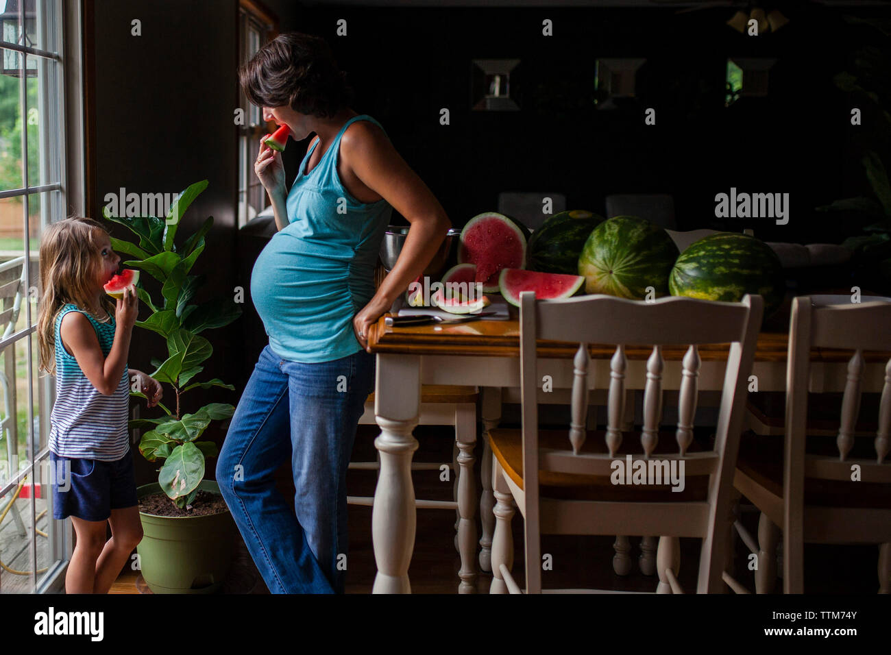 Mutter und Tochter essen Wassermelone zu Hause Stockfoto
