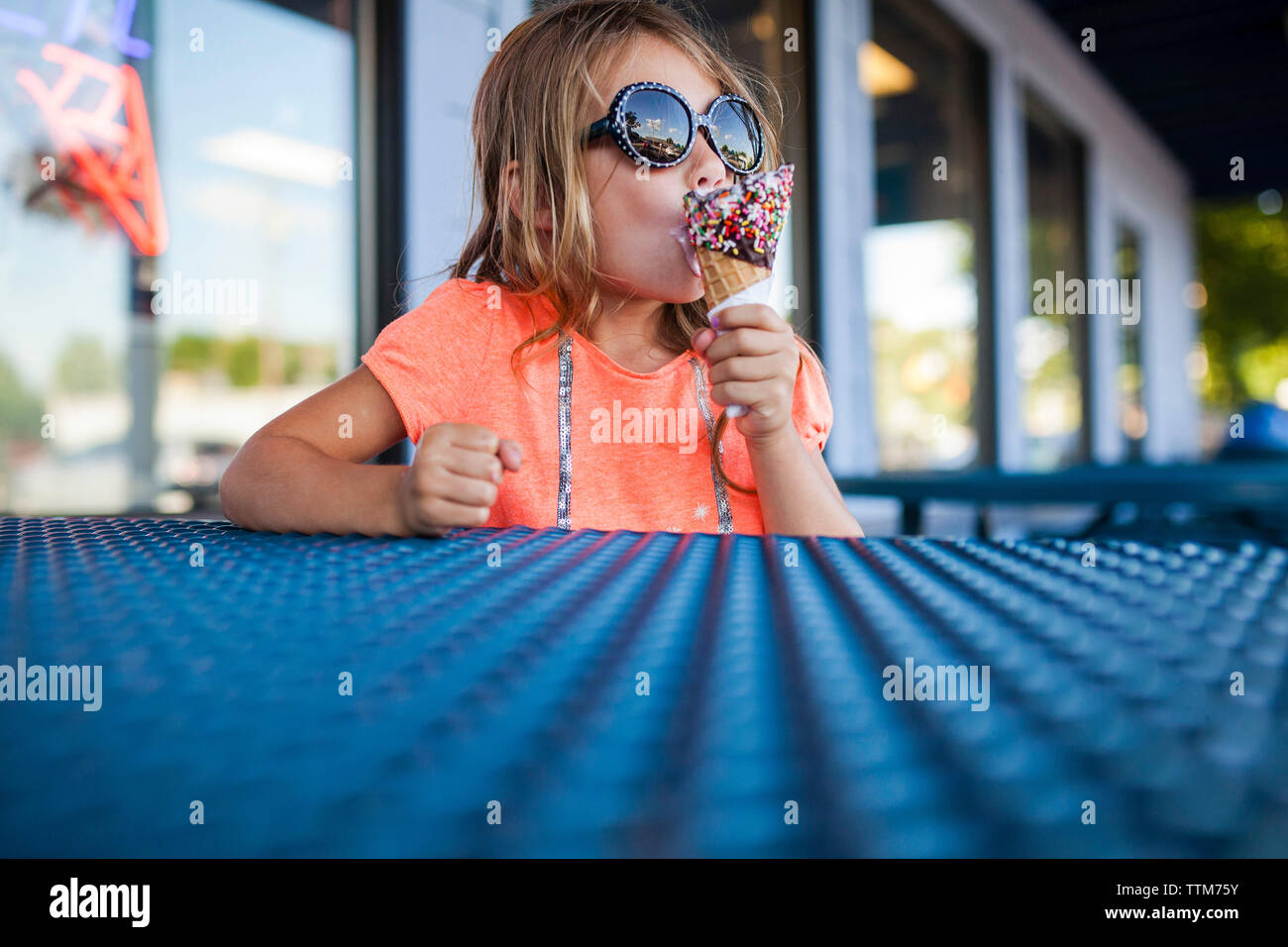 Mädchen in der Sonnenbrille essen Eis in der Eisdiele Stockfotografie -  Alamy