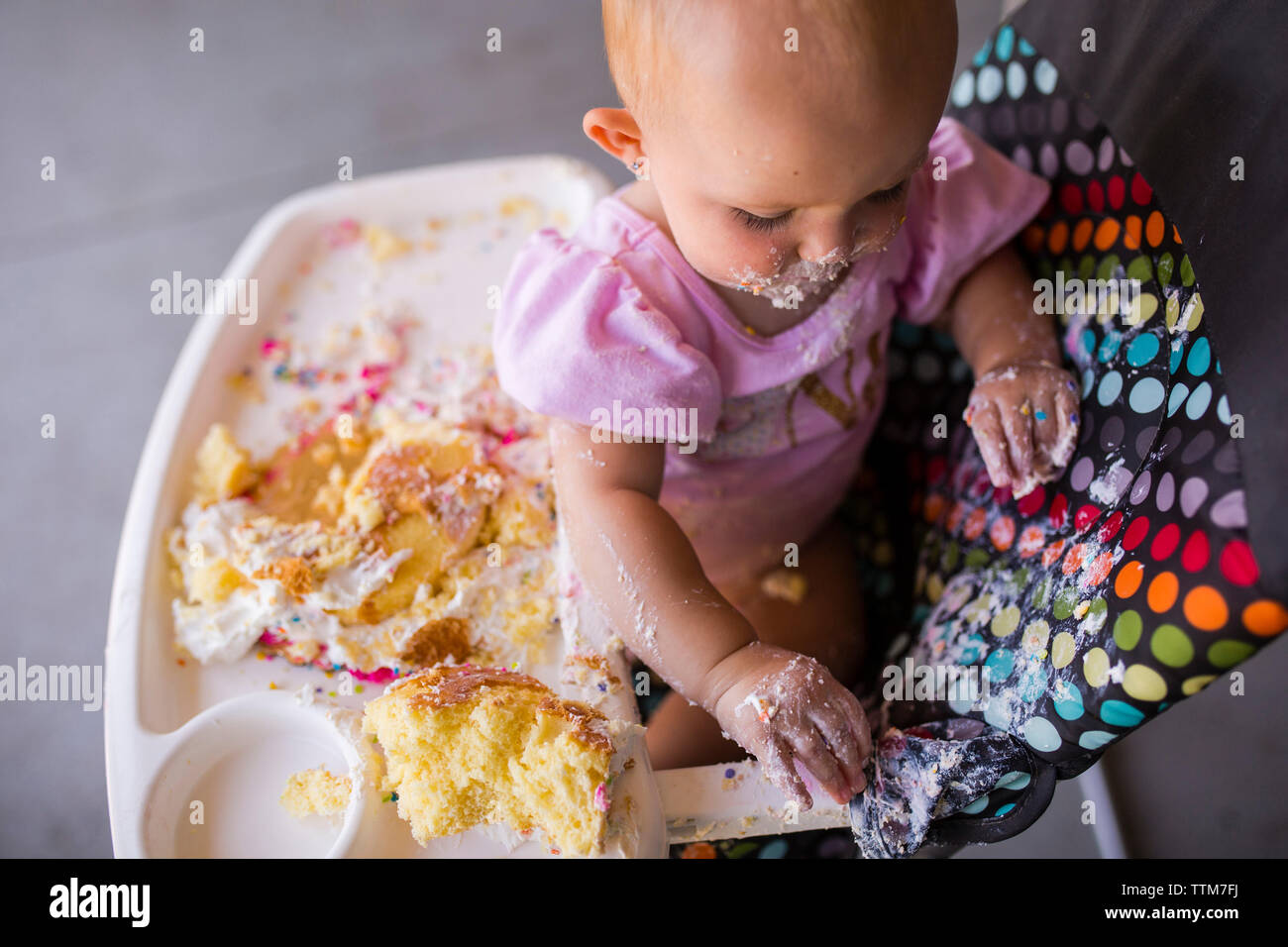 Hohe Betrachtungswinkel von baby girl Mit Essen spielen beim Sitzen auf hohen Stuhl zu Hause Stockfoto