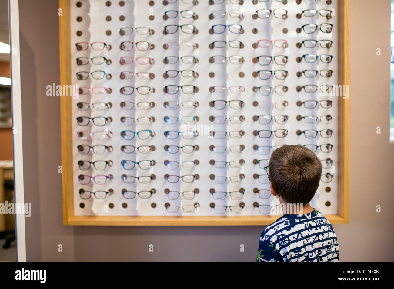 Junge mit Brille Auswahl im Auge Arztpraxis suchen Stockfoto