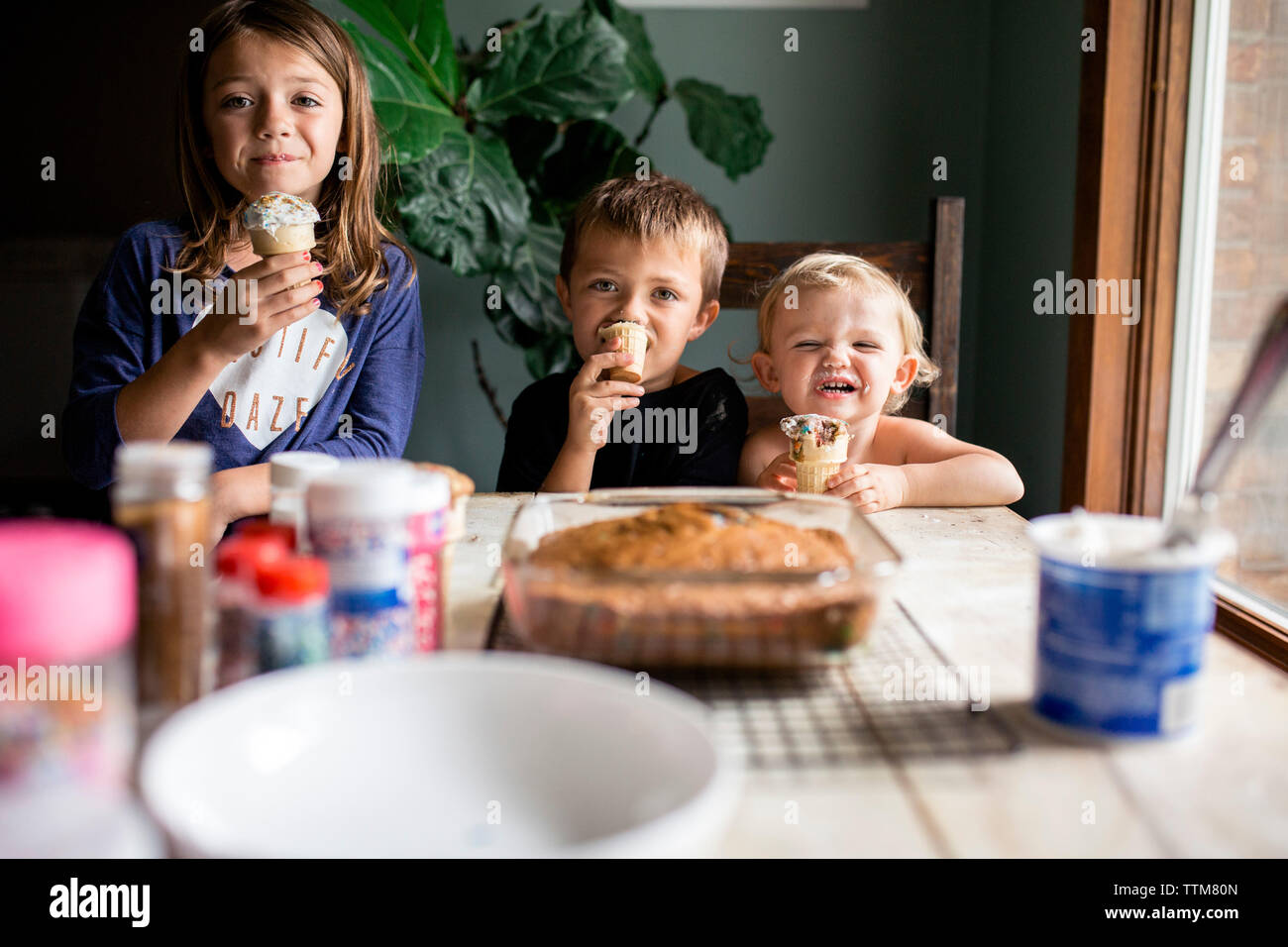 Drei Geschwister bonding über süßes Gebäck zu Hause Stockfoto