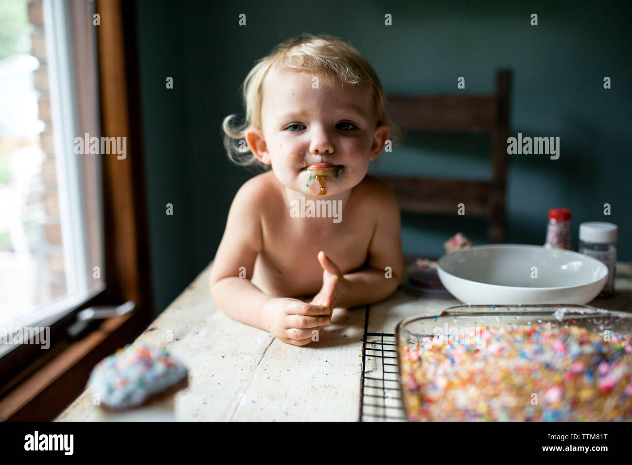 Kleinkind Mädchen saugen an der Lippe nach bunten süßen Leckereien Stockfoto