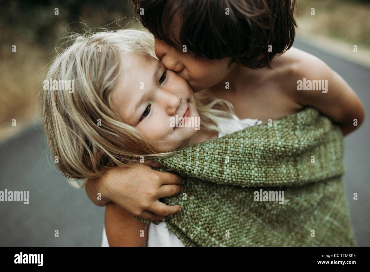 In der Nähe von Bruder küssen Schwester beim Stehen auf Landstraße Stockfoto