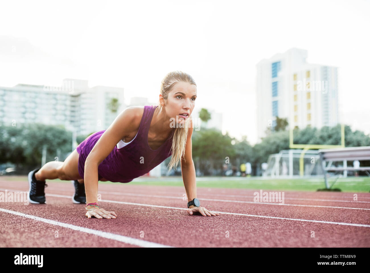 Bestimmt weiblichen Athleten, Push-ups auf der Rennstrecke Stockfoto