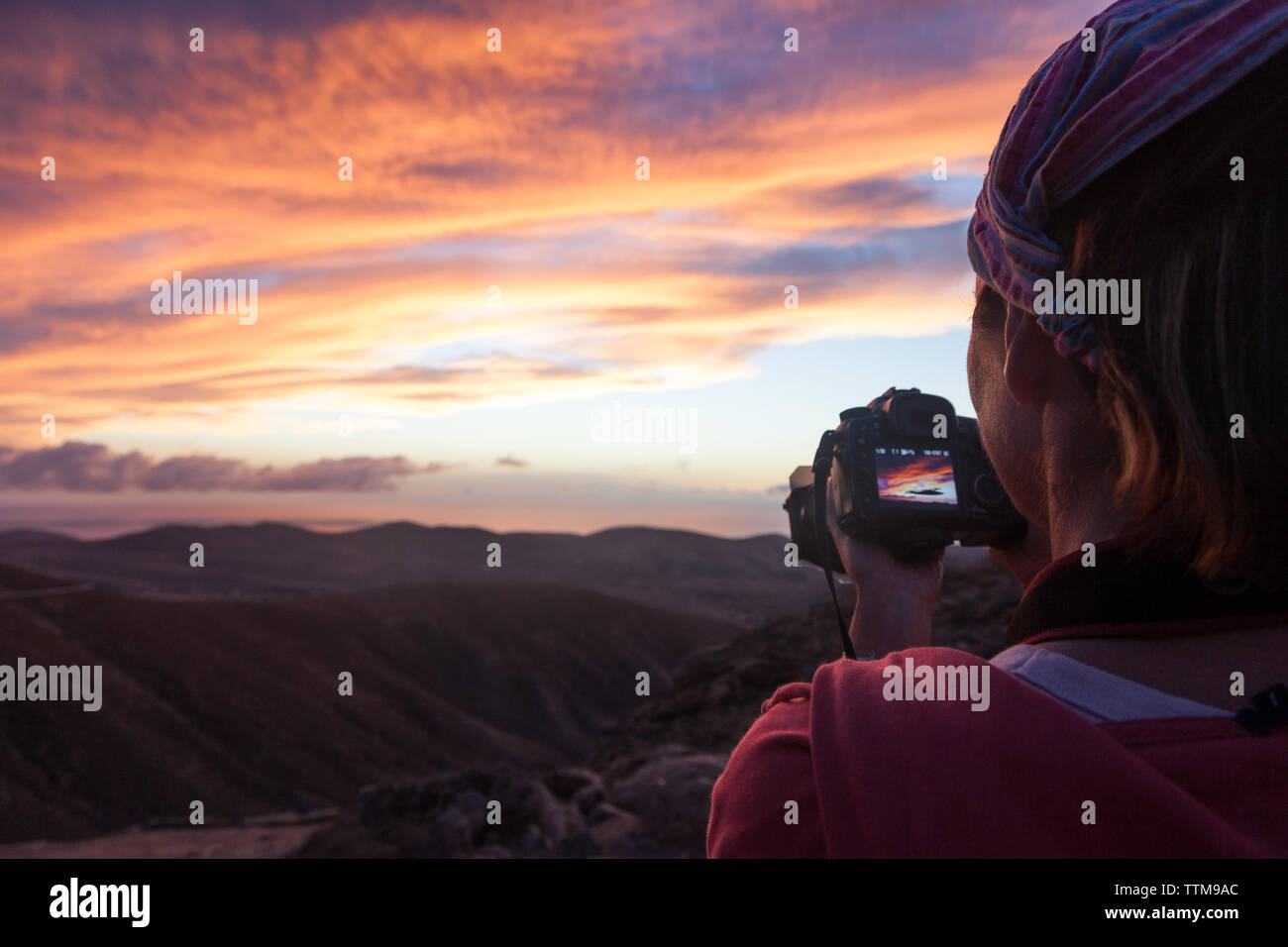 Fotograf ihre LCD-Display der Kamera bei Sonnenuntergang von einem hohen Punkt Stockfoto