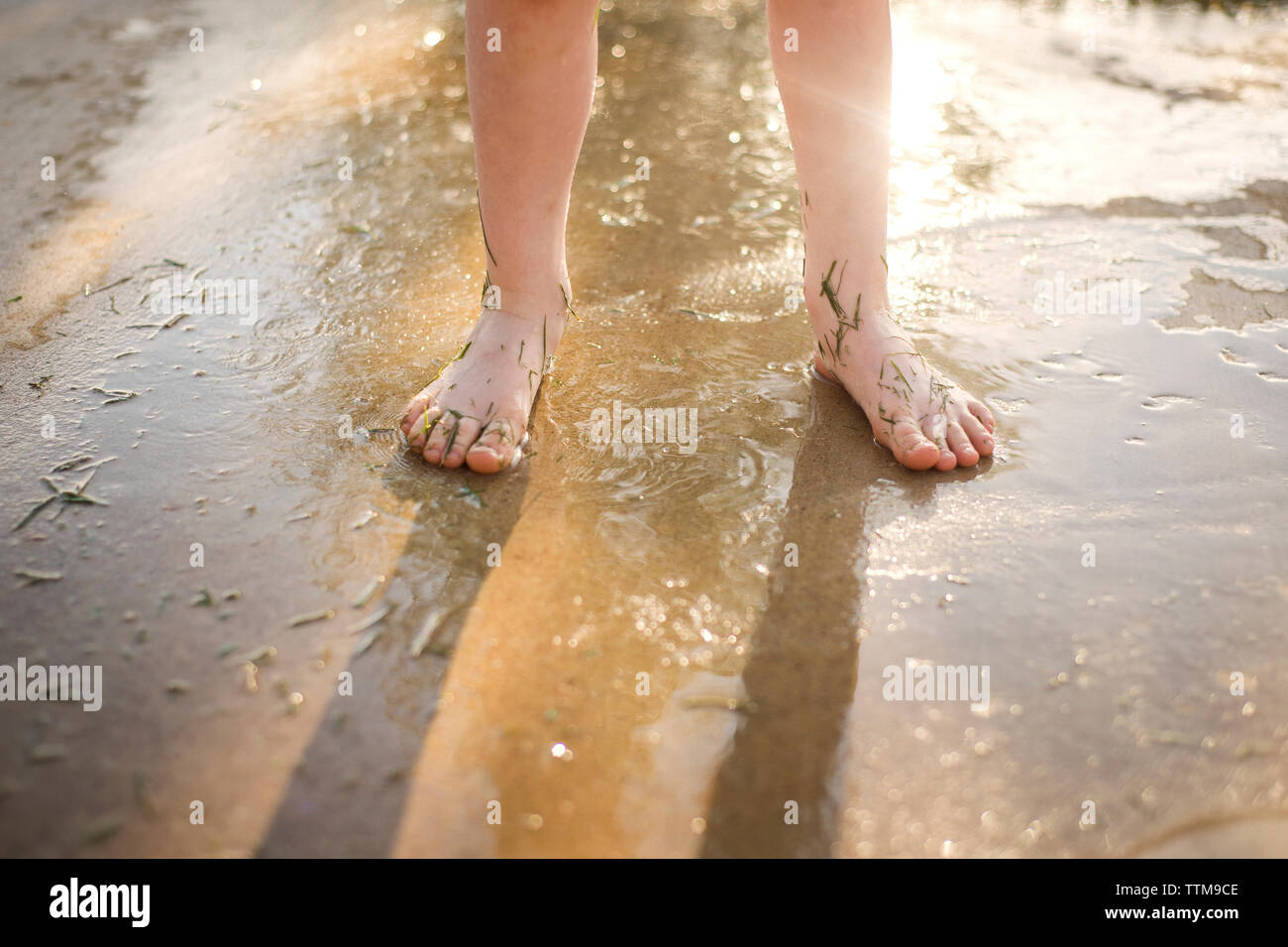 Low-Feld der Mädchen stehen auf nasser Straße Stockfoto