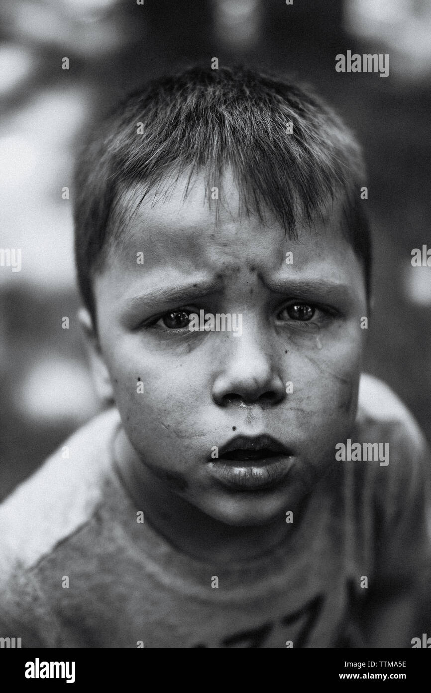 Ein kleiner Junge hat Tränen auf seinen Schmutz bedeckte Gesicht Stockfoto