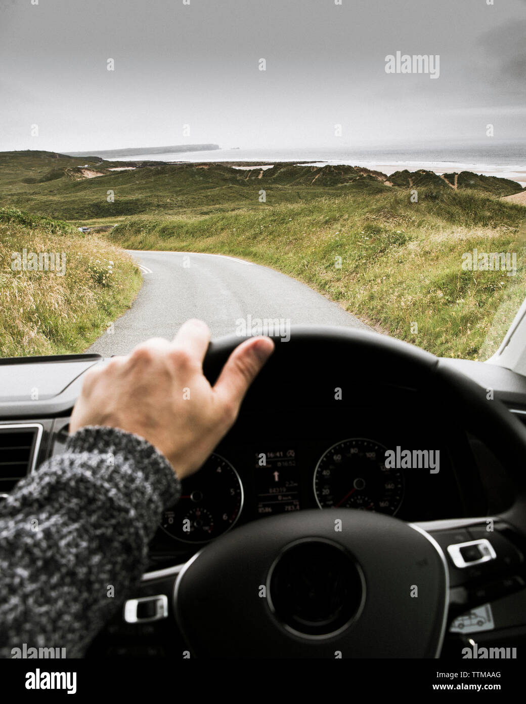 7/8 der Menschen Hand Auto auf der Straße gegen bewölkter Himmel Stockfoto