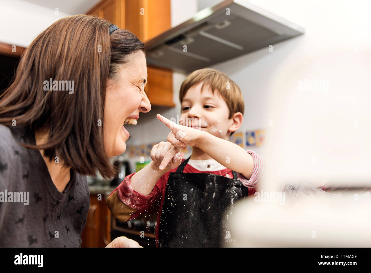 Mutter und Sohn Lachen während zusammen kochen Stockfoto