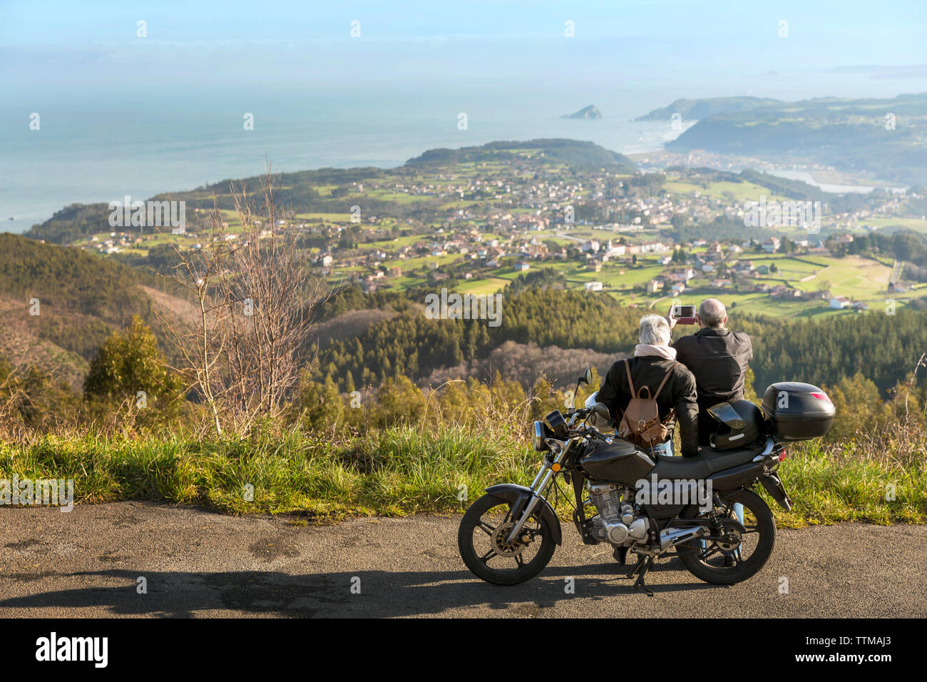 Senior Paar fotografieren Berge, während mit dem Motorrad auf der Straße Stockfoto